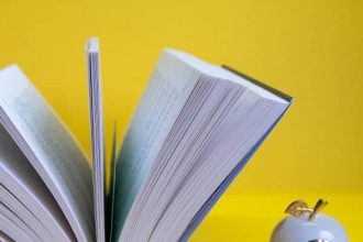 opened book yellow background with clock form apple near it 1
